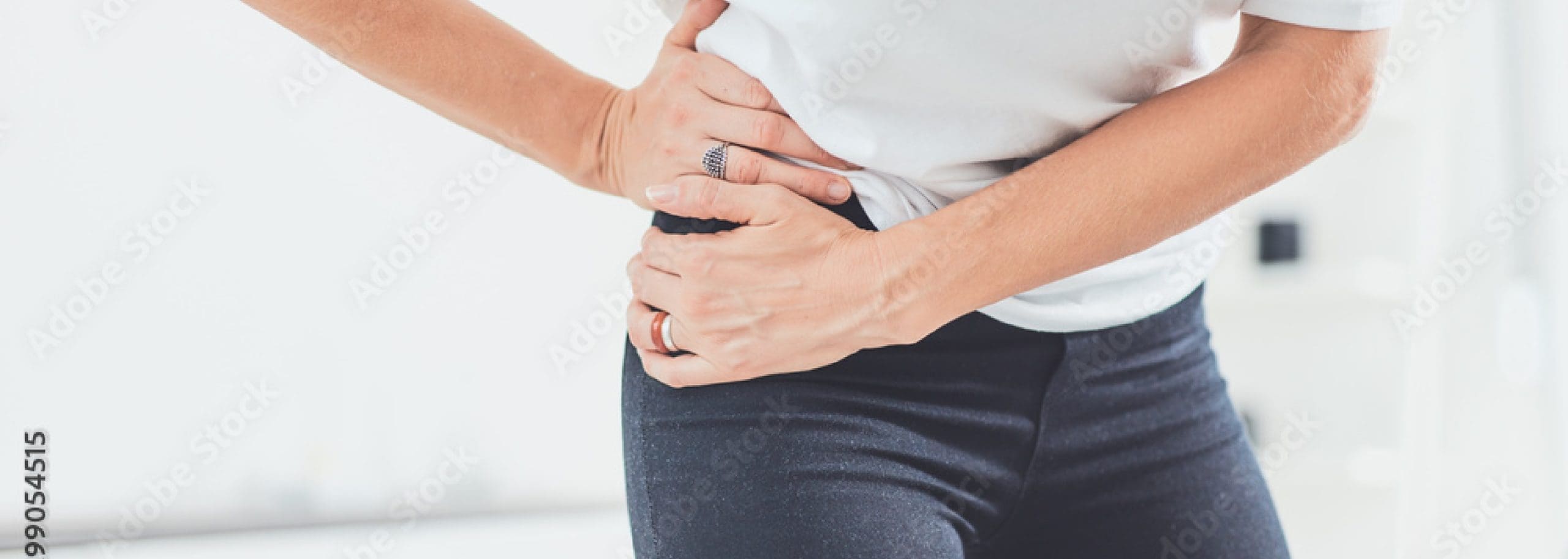Woman holding her right hip in pain