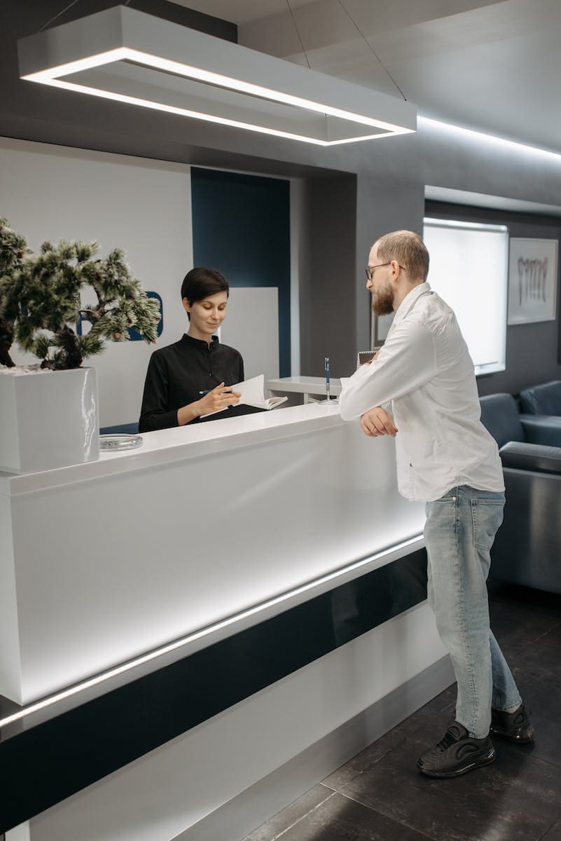 Man in White Dress Shirt Standing Near a Woman in the Reception